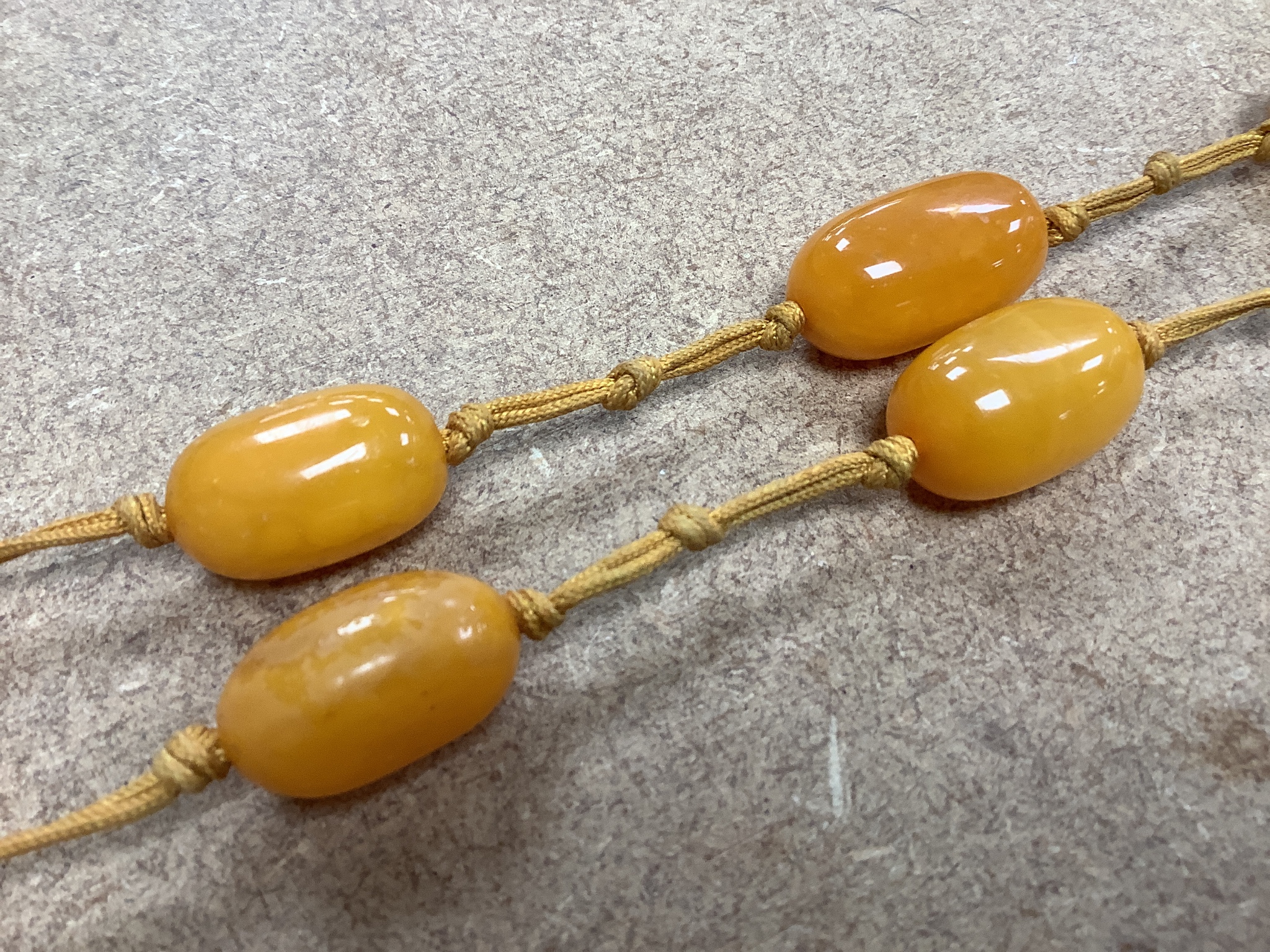 A single strand oval amber bead pendant necklace, 92cm, gross weight 60 grams.